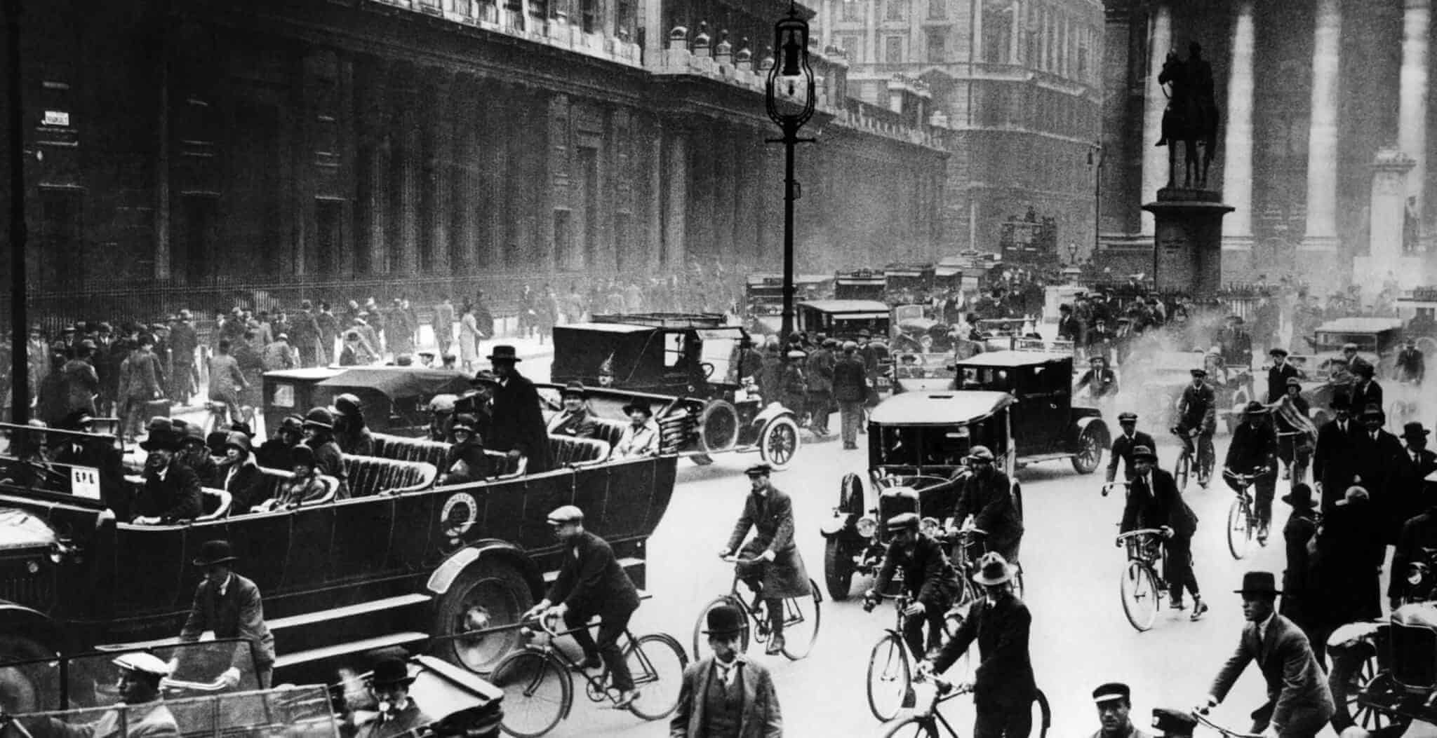 An overcrowded street, full of cars, bikes and people in Britain during the 1920's. 