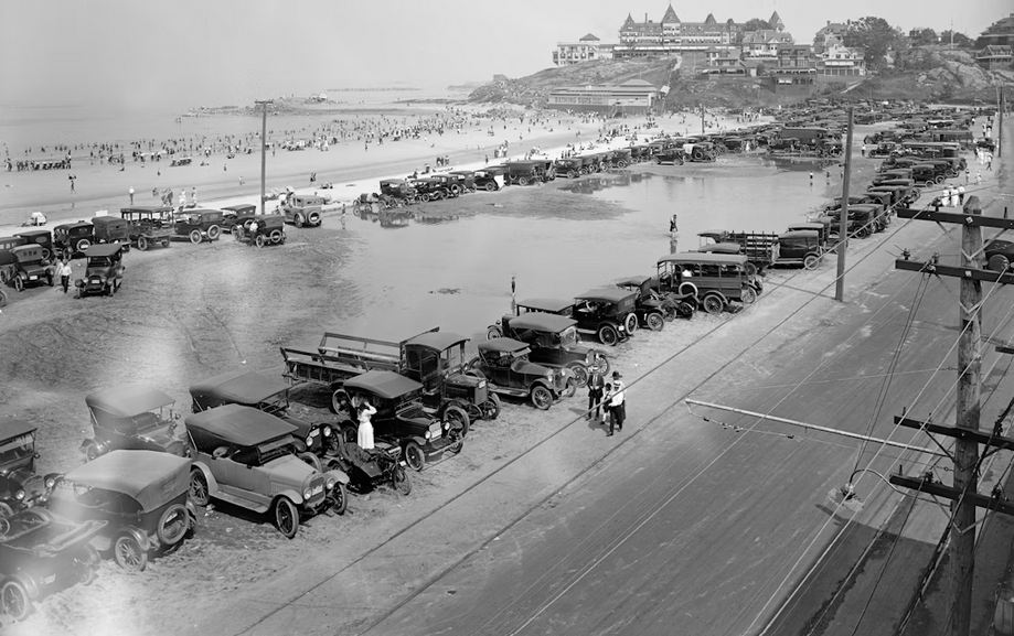 A beach with a bunch of old 1920s style cars