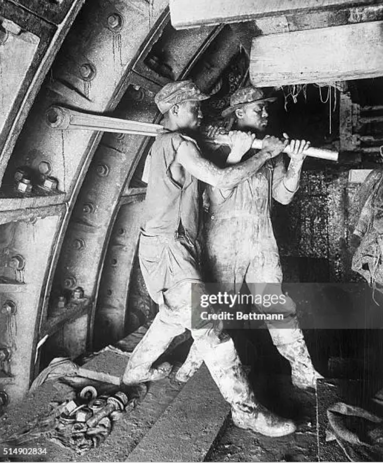 Two construction workers working on the Holland Tunnel.